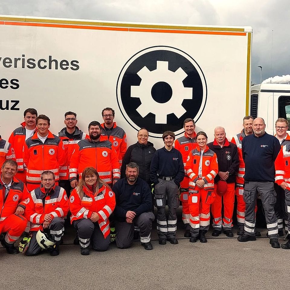Das Foto zeigt uniformierte BRK-Einsatzkräfte vor einem BRK-Lastwagen.